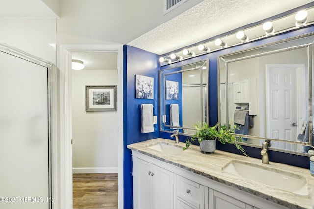 full bathroom featuring a shower stall, visible vents, and a sink