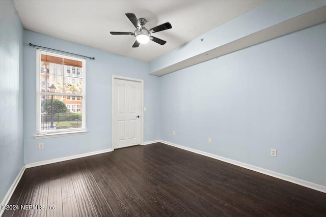 unfurnished room featuring dark wood-type flooring, ceiling fan, and baseboards