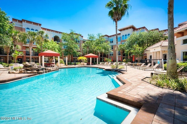 pool with a patio area, fence, and a gazebo