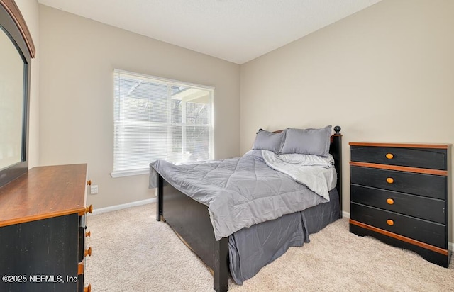 bedroom with light carpet, lofted ceiling, and baseboards