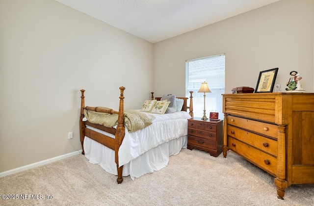 bedroom featuring light colored carpet and baseboards
