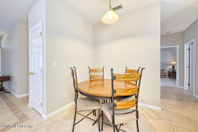 dining area with light tile patterned floors, baseboards, and visible vents