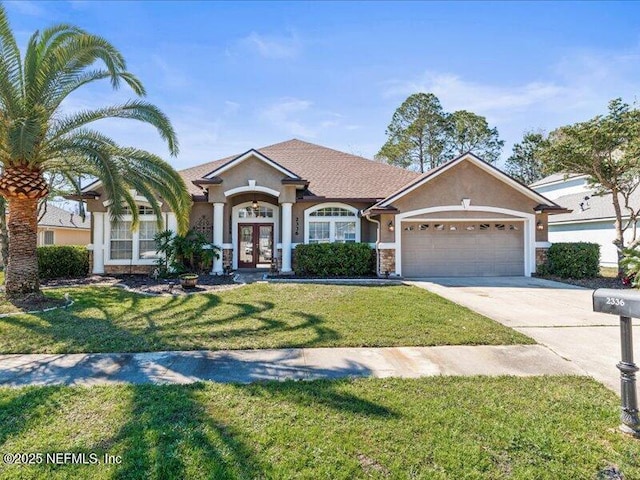 view of front facade with french doors, stucco siding, concrete driveway, a garage, and a front lawn