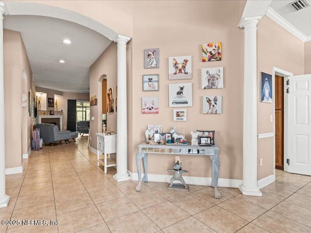 corridor featuring visible vents, light tile patterned flooring, decorative columns, and baseboards