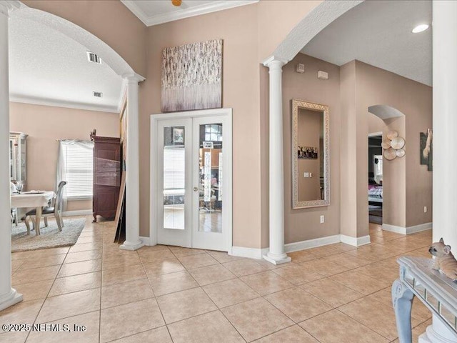 foyer entrance featuring light tile patterned floors, visible vents, french doors, ornamental molding, and ornate columns