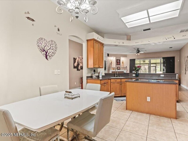 kitchen featuring a center island, a sink, a peninsula, and a kitchen bar