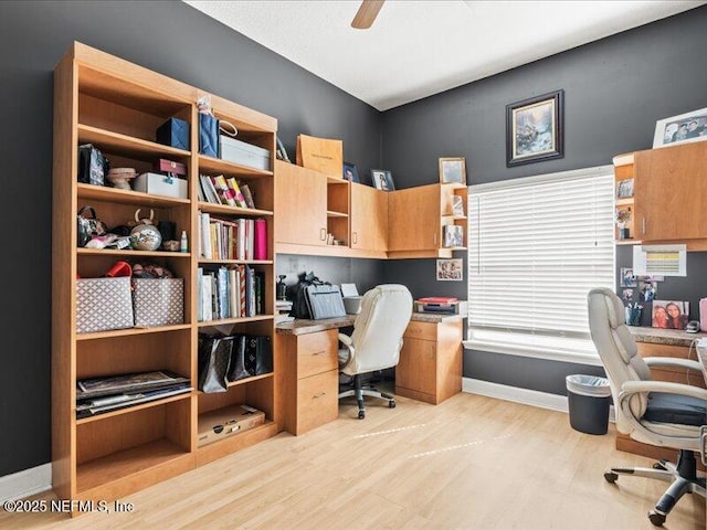 office featuring lofted ceiling, light wood-style floors, baseboards, and a ceiling fan