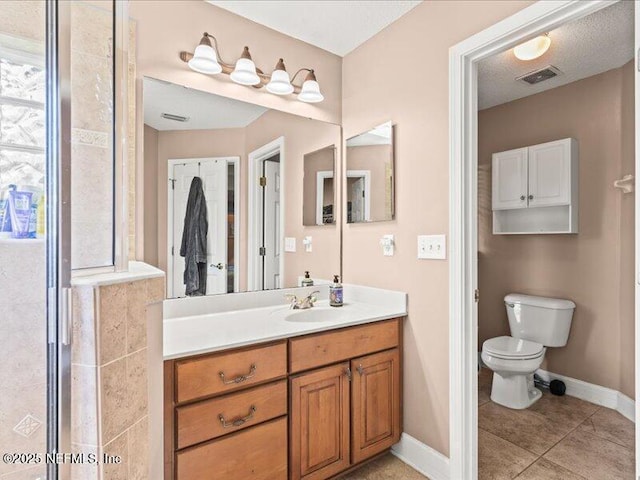 bathroom featuring toilet, tile patterned flooring, baseboards, and vanity