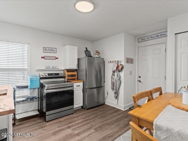 kitchen with appliances with stainless steel finishes, light countertops, and white cabinets