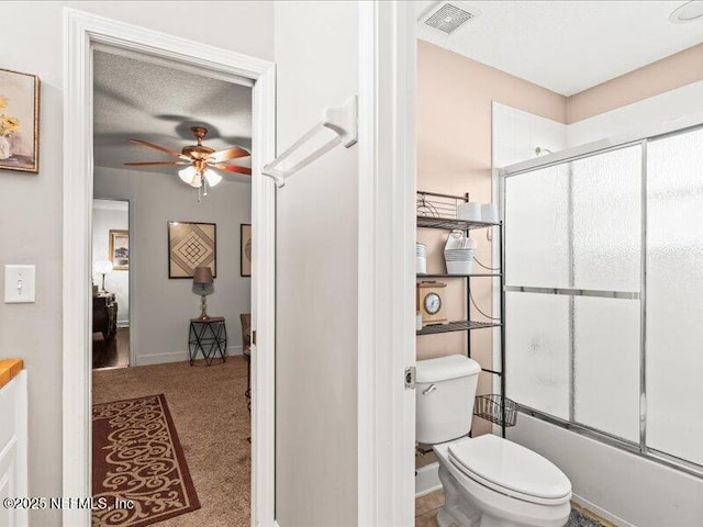 full bath with visible vents, toilet, combined bath / shower with glass door, ceiling fan, and a textured ceiling