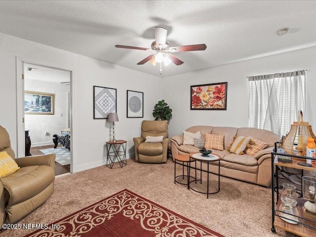 living area featuring carpet floors, ceiling fan, a textured ceiling, and baseboards