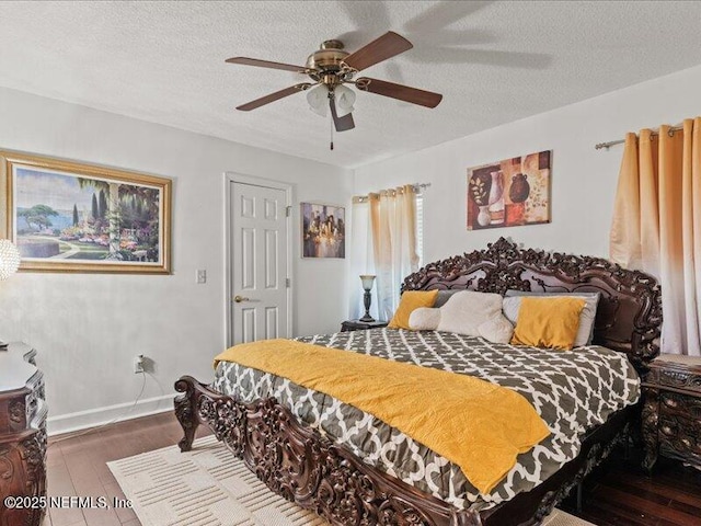 bedroom with a textured ceiling, ceiling fan, wood finished floors, and baseboards