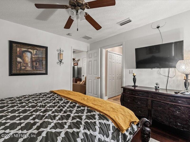 bedroom featuring a textured ceiling, a closet, visible vents, and a ceiling fan