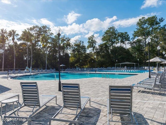 community pool with a patio and fence