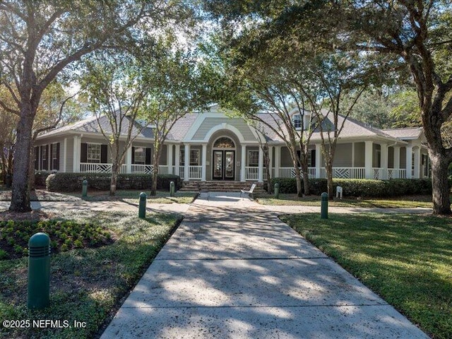 single story home featuring a front yard, french doors, and driveway