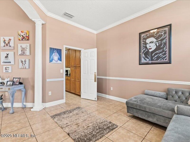 interior space featuring light tile patterned floors, decorative columns, visible vents, baseboards, and crown molding