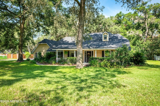 cape cod home featuring a front lawn and fence