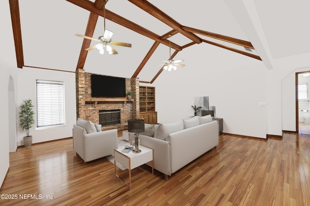 living room featuring plenty of natural light, a brick fireplace, and light wood-style flooring