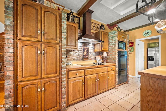 kitchen featuring light countertops, light tile patterned flooring, wall chimney range hood, a textured ceiling, and black appliances