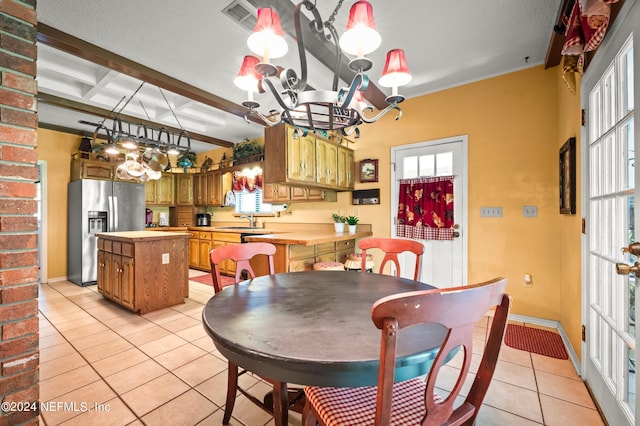 dining space featuring light tile patterned floors, a chandelier, coffered ceiling, visible vents, and a healthy amount of sunlight