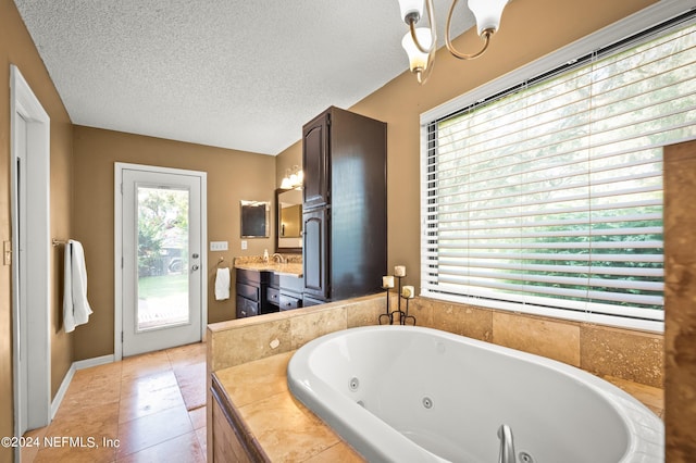 full bath with a whirlpool tub, a textured ceiling, vanity, and tile patterned floors