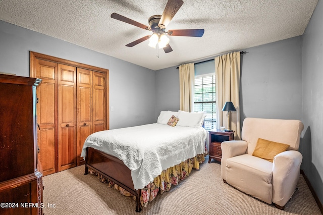 bedroom with a ceiling fan, a closet, light carpet, and a textured ceiling