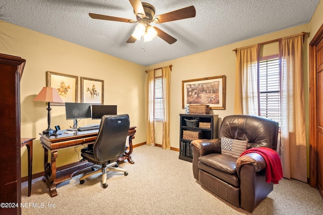 home office featuring a textured ceiling, ceiling fan, light carpet, and baseboards