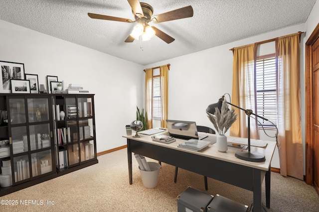 carpeted office with ceiling fan, a textured ceiling, and baseboards