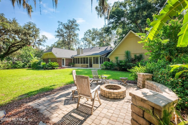 view of patio / terrace with a sunroom and an outdoor fire pit