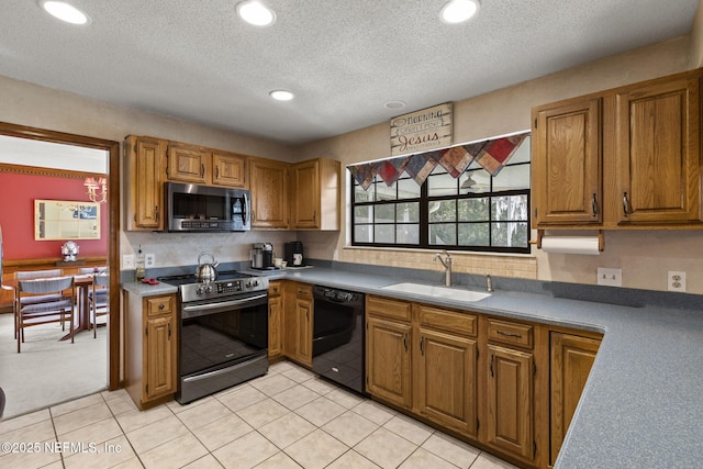 kitchen with appliances with stainless steel finishes, recessed lighting, a sink, and brown cabinets