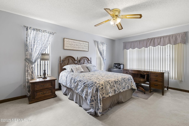 bedroom featuring light carpet, a textured ceiling, and baseboards