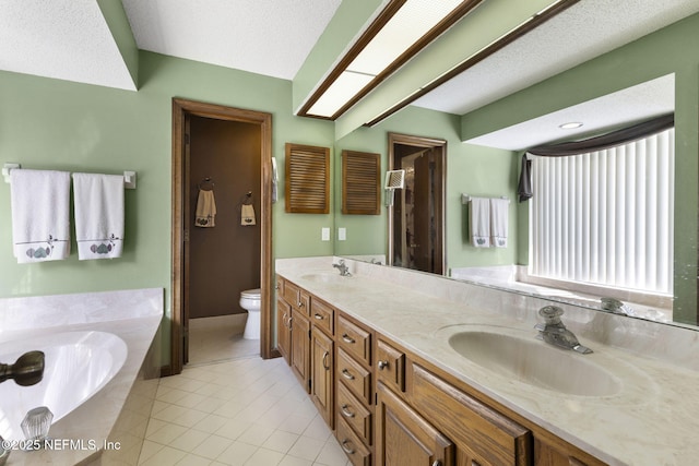 bathroom with double vanity, toilet, a sink, tile patterned flooring, and a bath