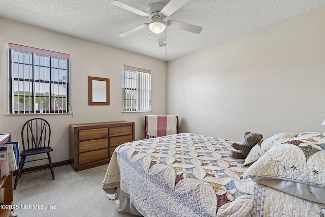 bedroom featuring ceiling fan, baseboards, a textured ceiling, and light colored carpet