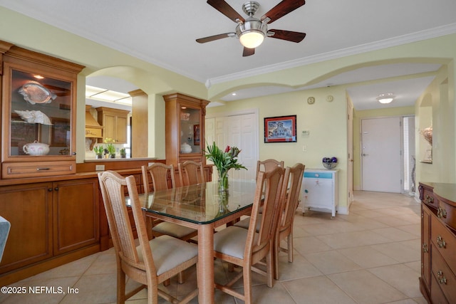 dining space featuring ceiling fan, crown molding, and light tile patterned floors