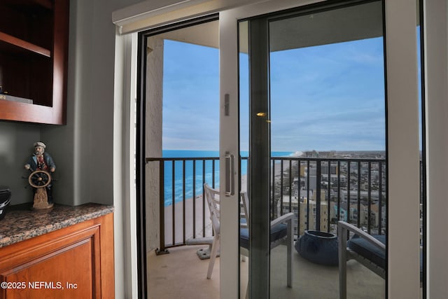 balcony featuring a beach view and a water view