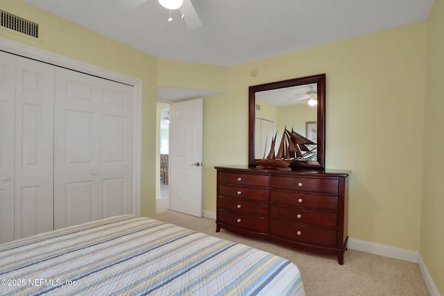 bedroom featuring a closet, light carpet, visible vents, and baseboards