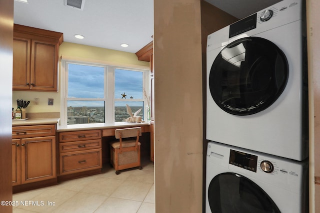 laundry area featuring laundry area, light tile patterned floors, visible vents, stacked washer / dryer, and recessed lighting