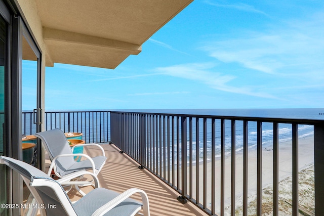 balcony featuring a water view and a view of the beach