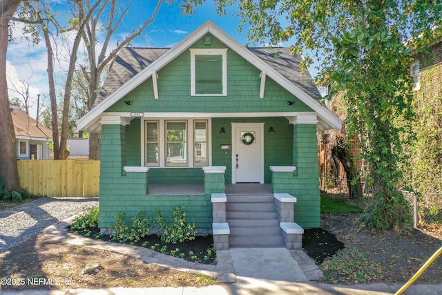 bungalow-style house with roof with shingles and fence