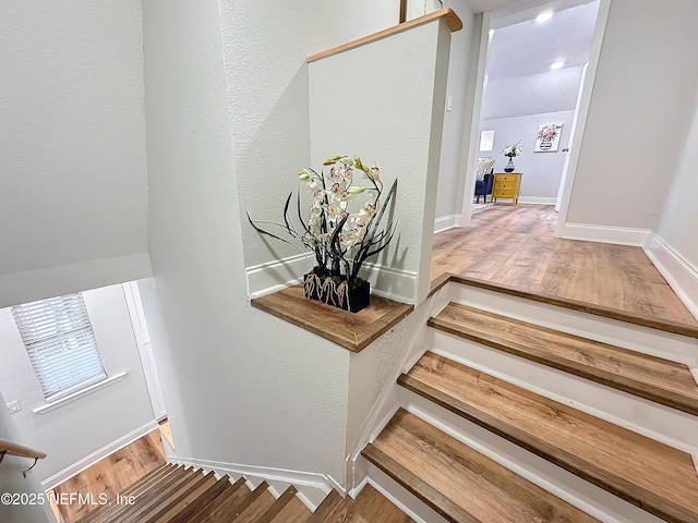 stairs with wood finished floors and baseboards