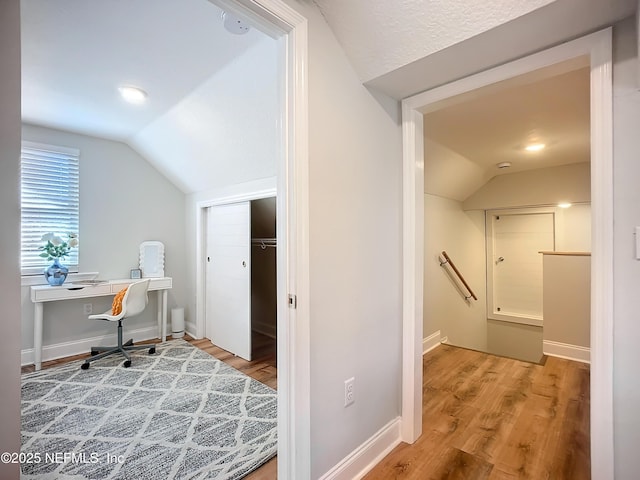 office featuring vaulted ceiling, baseboards, and wood finished floors