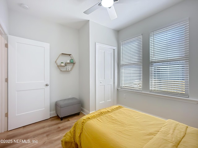 bedroom with a ceiling fan, a closet, and wood finished floors