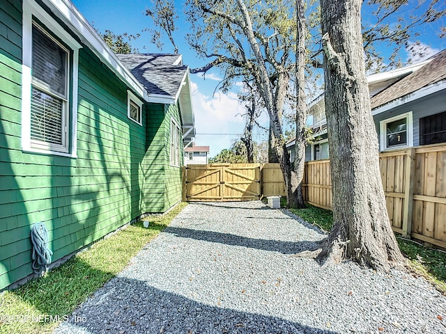 exterior space featuring driveway, fence, and a gate