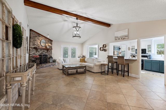 living area featuring beamed ceiling, a textured ceiling, french doors, a fireplace, and light tile patterned flooring