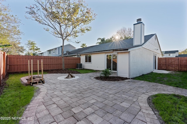 back of property featuring a patio area, a fenced backyard, a chimney, and stucco siding