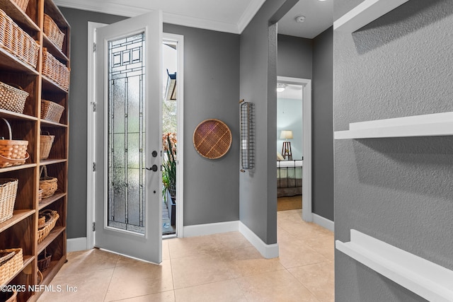 entryway featuring ornamental molding, tile patterned flooring, a wealth of natural light, and baseboards