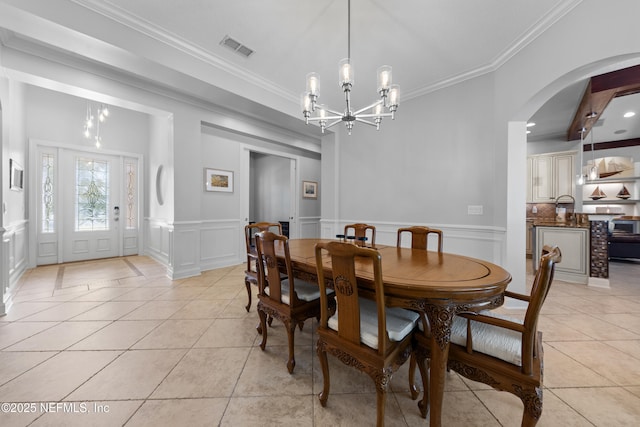 dining room with light tile patterned floors, visible vents, arched walkways, and a chandelier