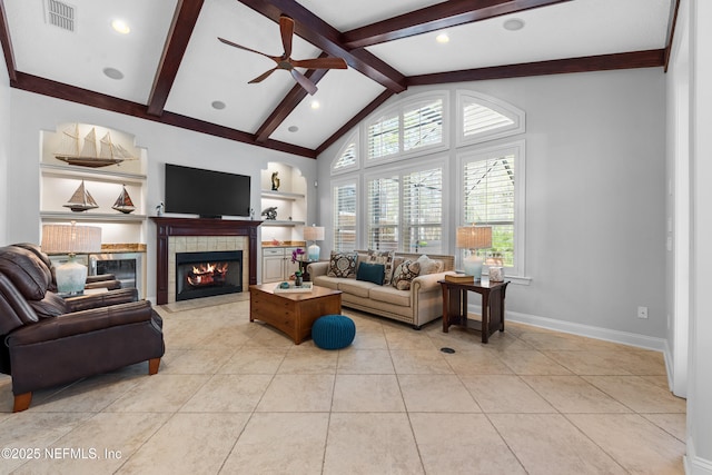 living area with visible vents, a ceiling fan, built in features, a fireplace, and vaulted ceiling with beams