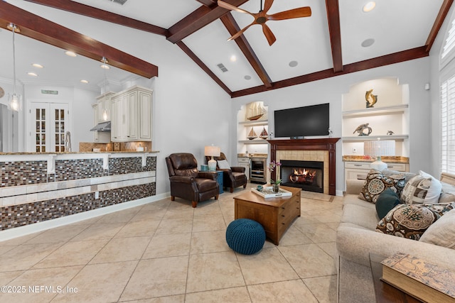 living room with light tile patterned floors, visible vents, beam ceiling, ceiling fan, and a tiled fireplace