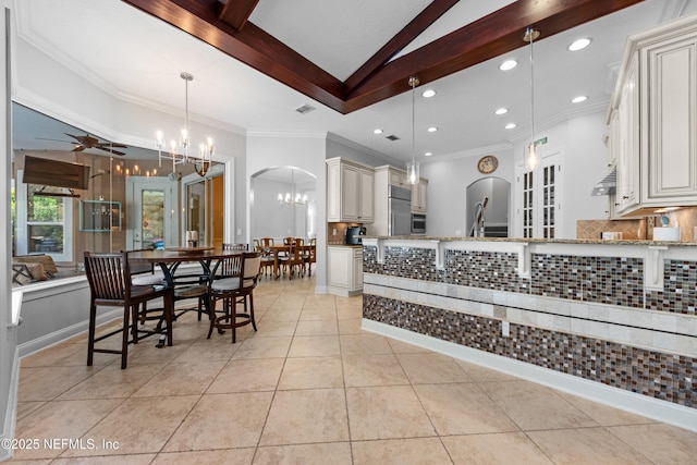 kitchen featuring light tile patterned floors, light stone countertops, tasteful backsplash, and a chandelier